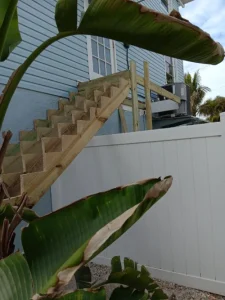 A wooden staircase going up to the top of stairs.