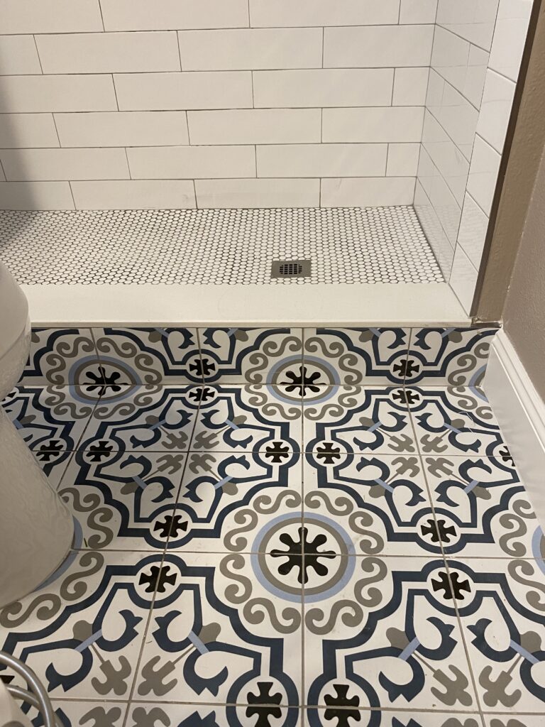 A bathroom with a tiled floor and white walls.
