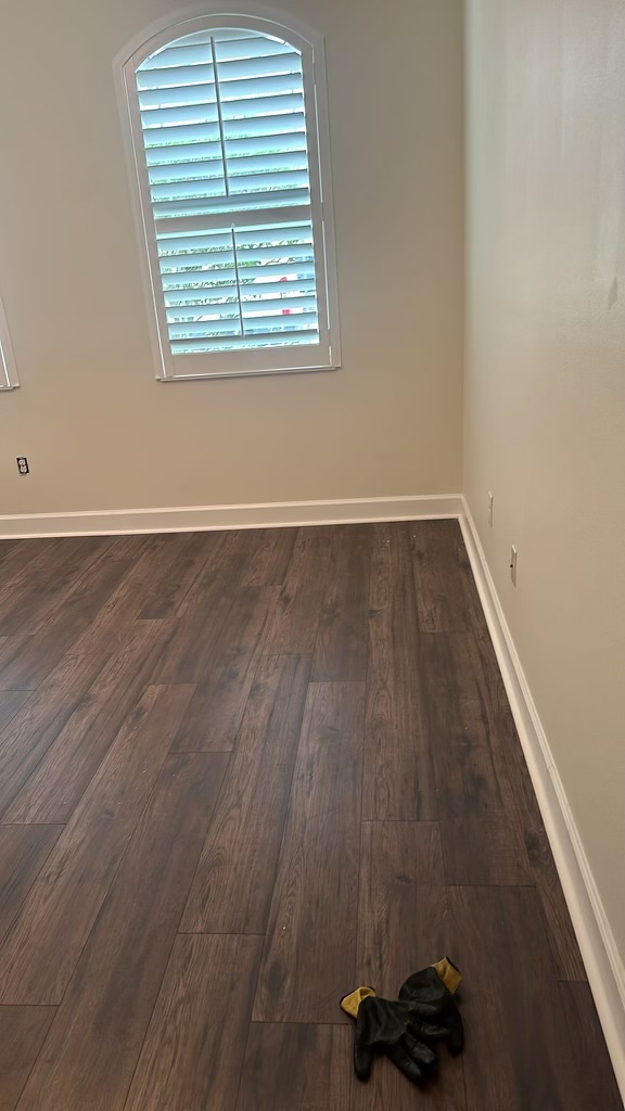 A room with wood floors and white walls.