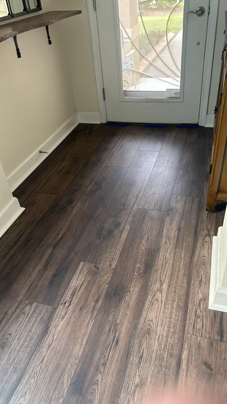 A hallway with wooden floors and a door.