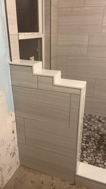 A bathroom with a tiled shower and tile floor.